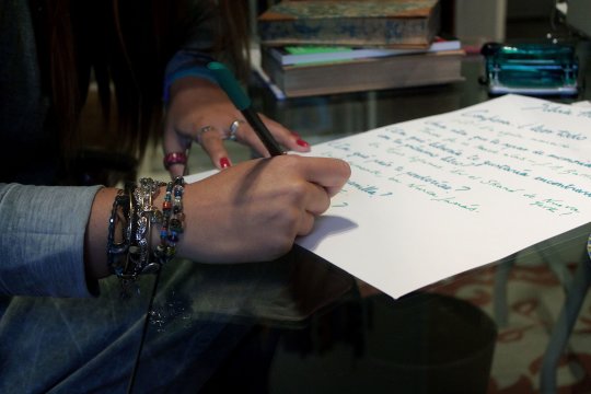 Silvia Herreros escribiendo sobre una hoja de papel