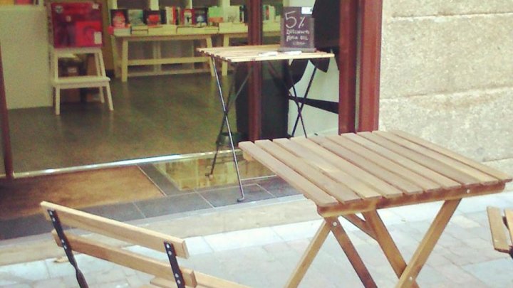 Mesas y sillas en el exterior de la librería La Sombra